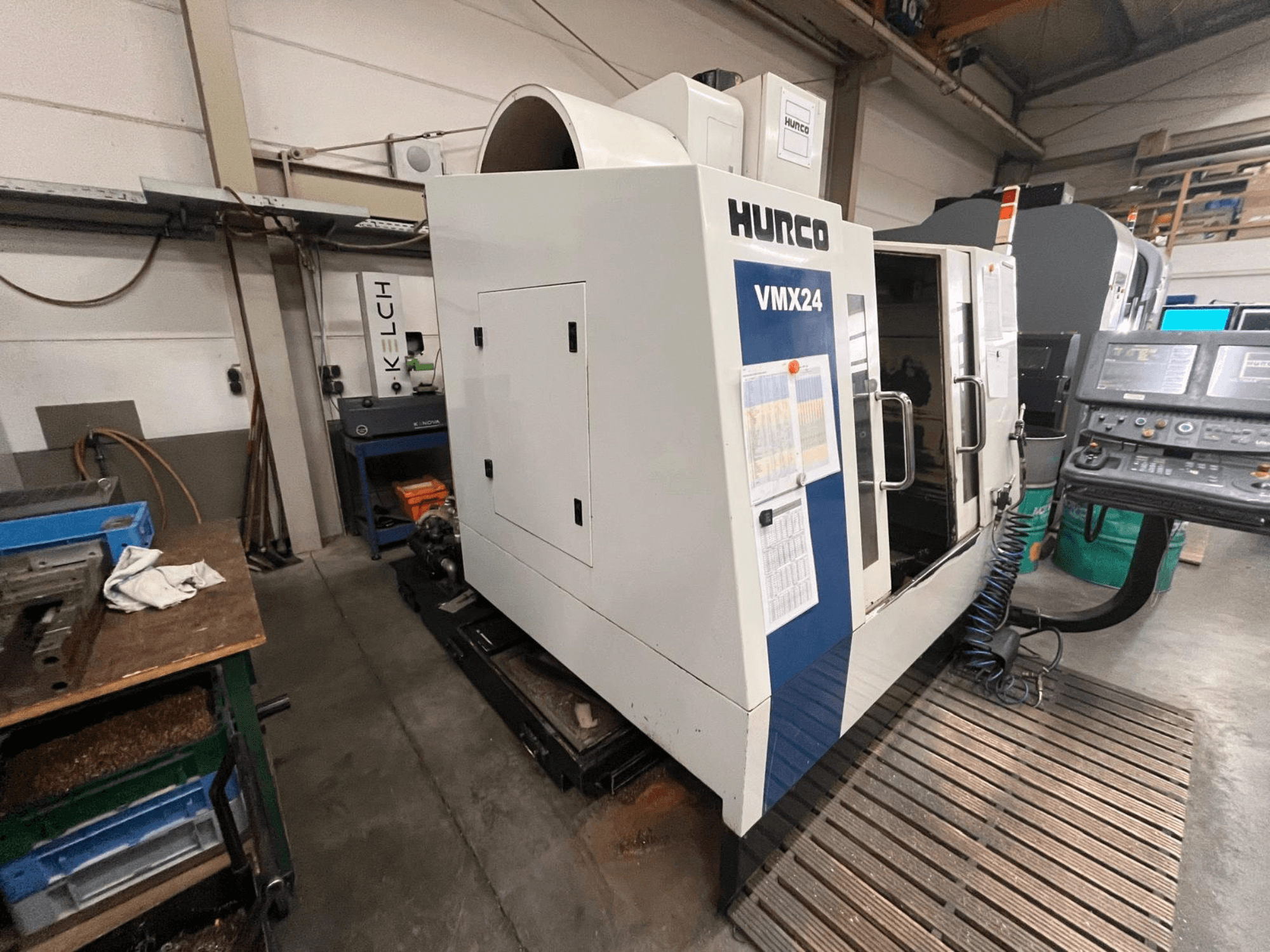 Hurco VMX24 CNC machine in a workshop, front view; features a control panel and open access door.