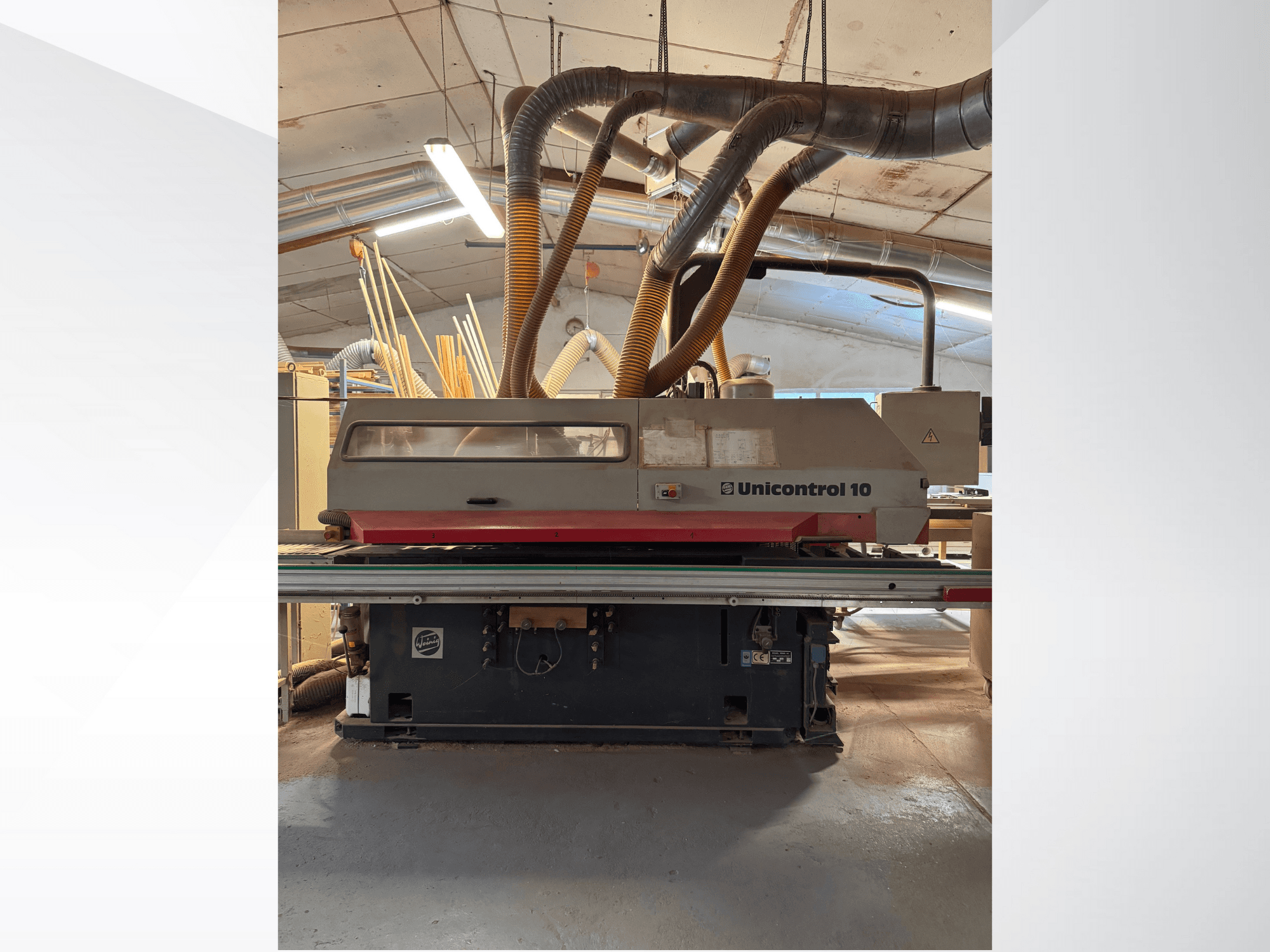 Vorderansicht einer Unicontrol 10 Holzbearbeitungsmaschine mit Staubabsaugrohren und Bedienelementen.