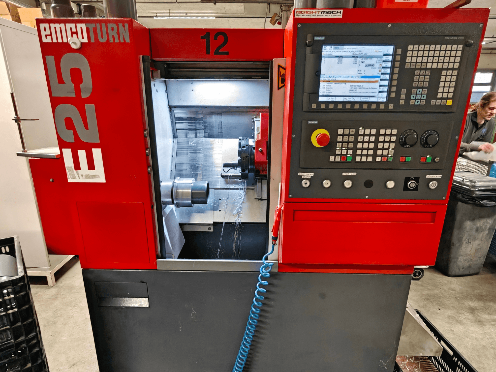 Vorderansicht der EMCO TURN E25 Maschine, mit Bedienfeld, Werkzeughalter und Innenraum mit sichtbarem Schneidwerkzeug.