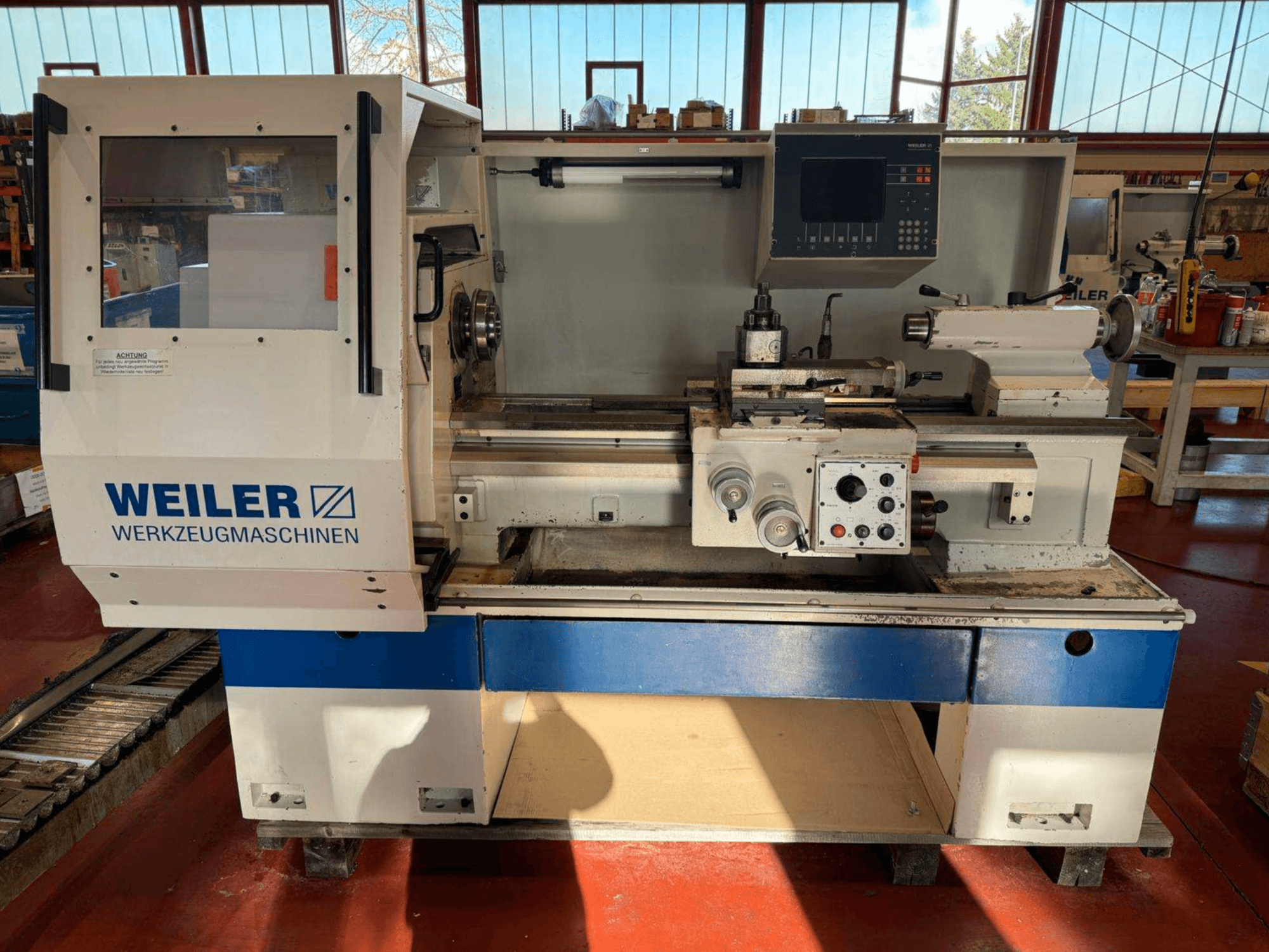 Weiler E35 Horizontal-Drehmaschine in der Vorderansicht, mit Bedienfeld und Drehteilen.