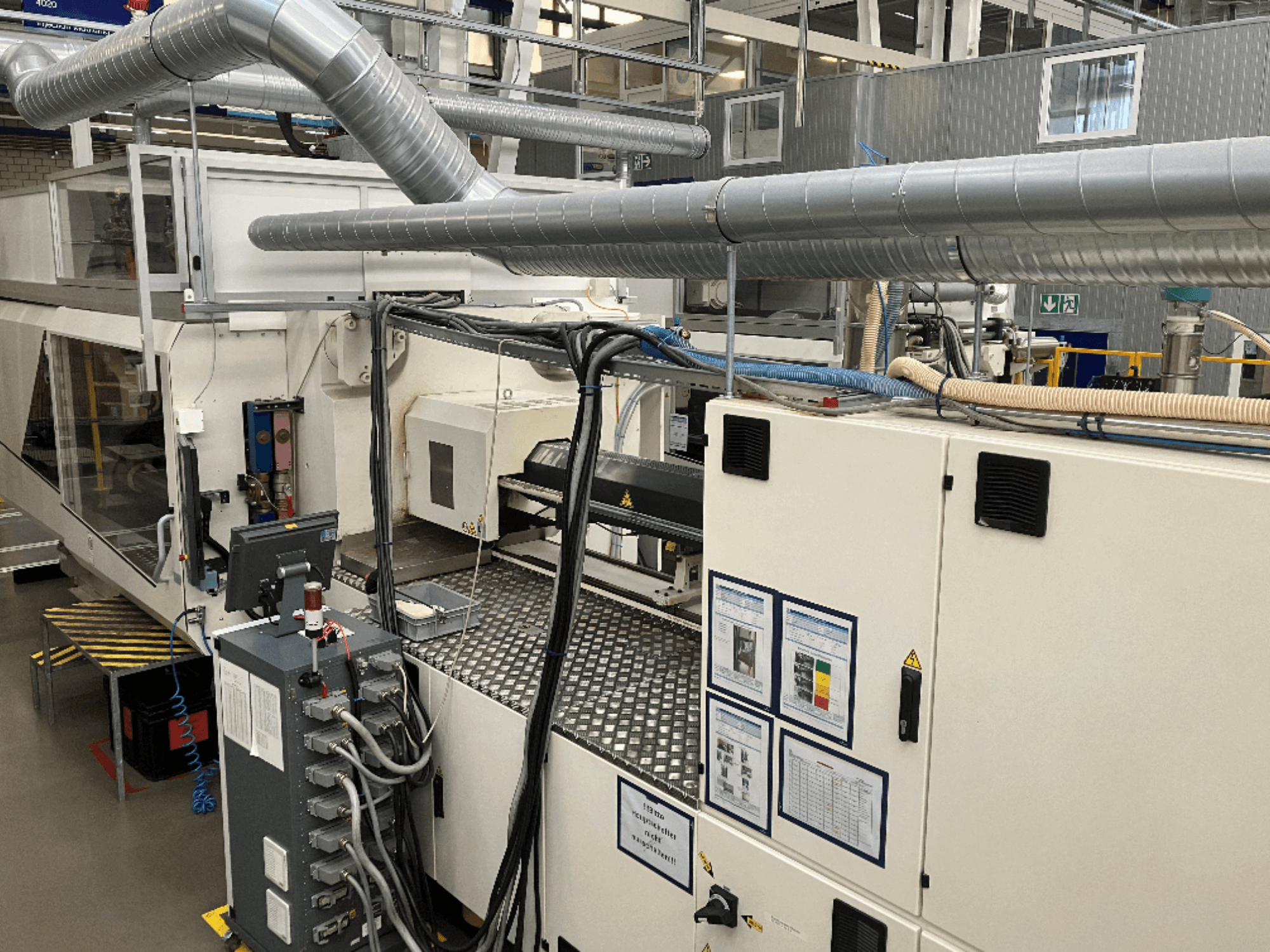 Industriemaschinen mit umfangreichen Rohrleitungen, Schalttafeln und Bedienungsanleitungen, von oben nach unten betrachtet.