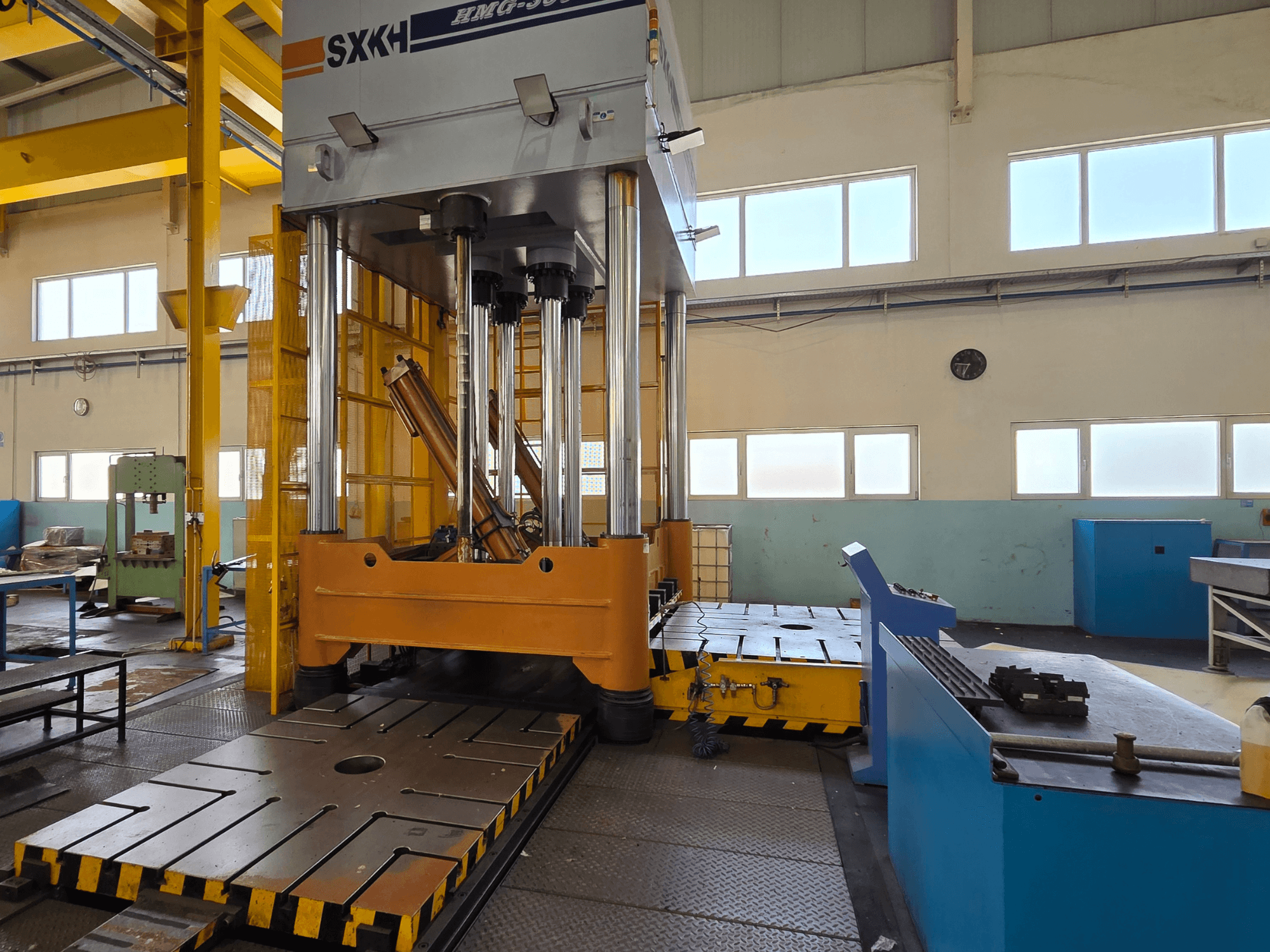 Vorderansicht der hydraulischen Presse SXKH HMG-300JM mit großen Presszylindern und einem robusten Unterbau in einer Fabrikhalle.