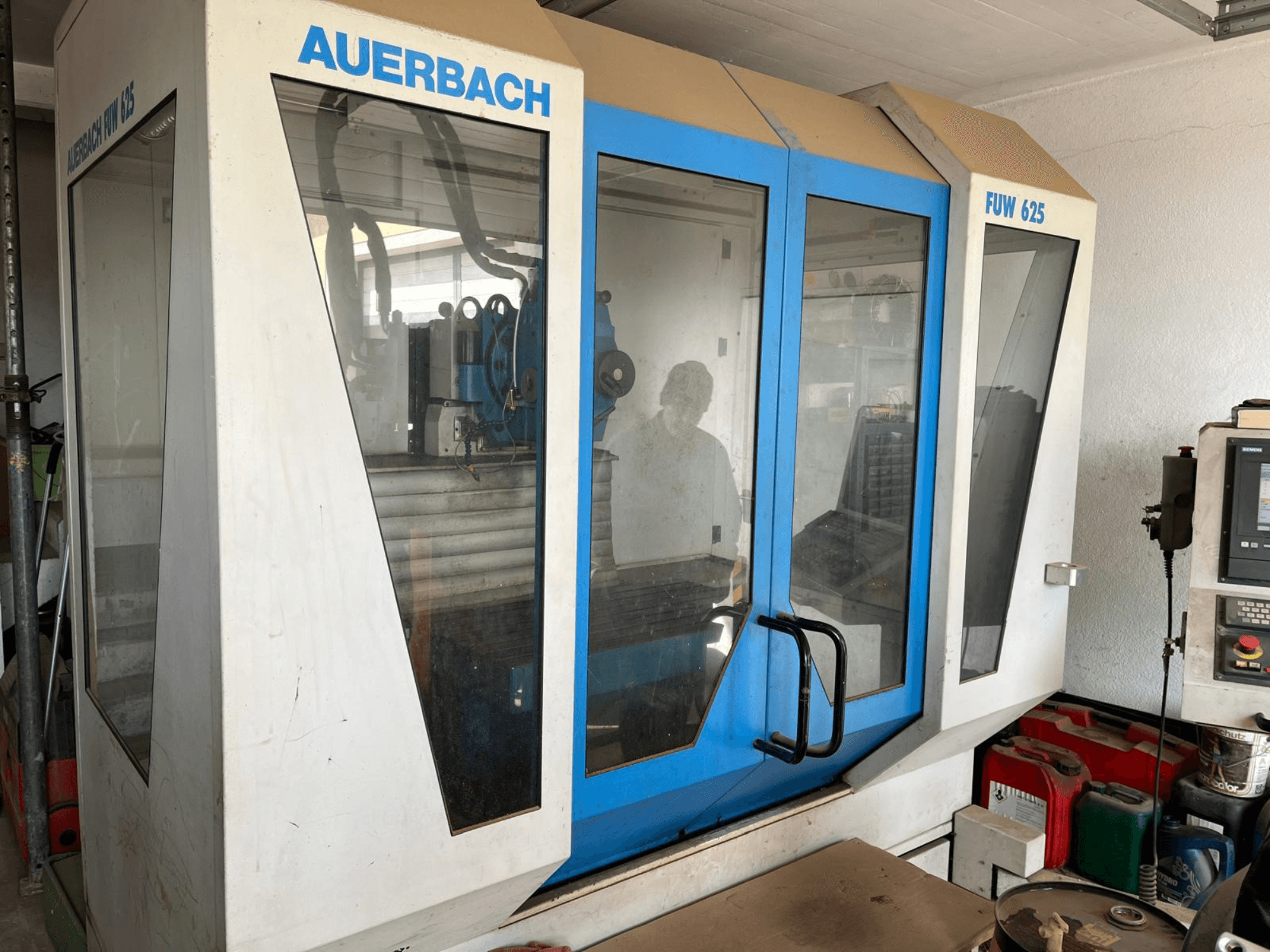 Auerbach Universal-Bearbeitungszentrum FUW 625 in der Seitenansicht mit Glasscheiben und einem Bedienpult auf der rechten Seite.