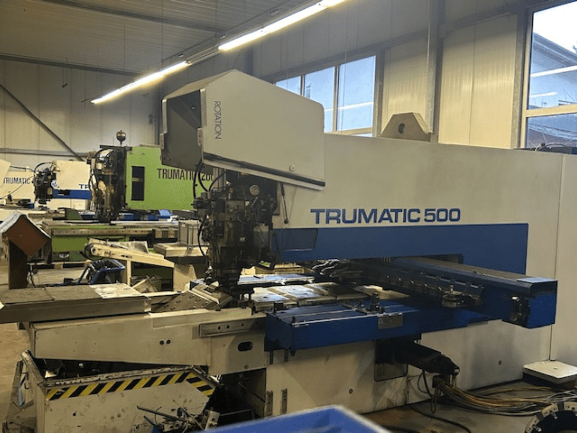 TRUMPF TRUMATIC 500 CNC-Stanzmaschine, Vorderansicht, mit Bedienfeld und mechanischen Teilen. Industrielle Werkstattumgebung.