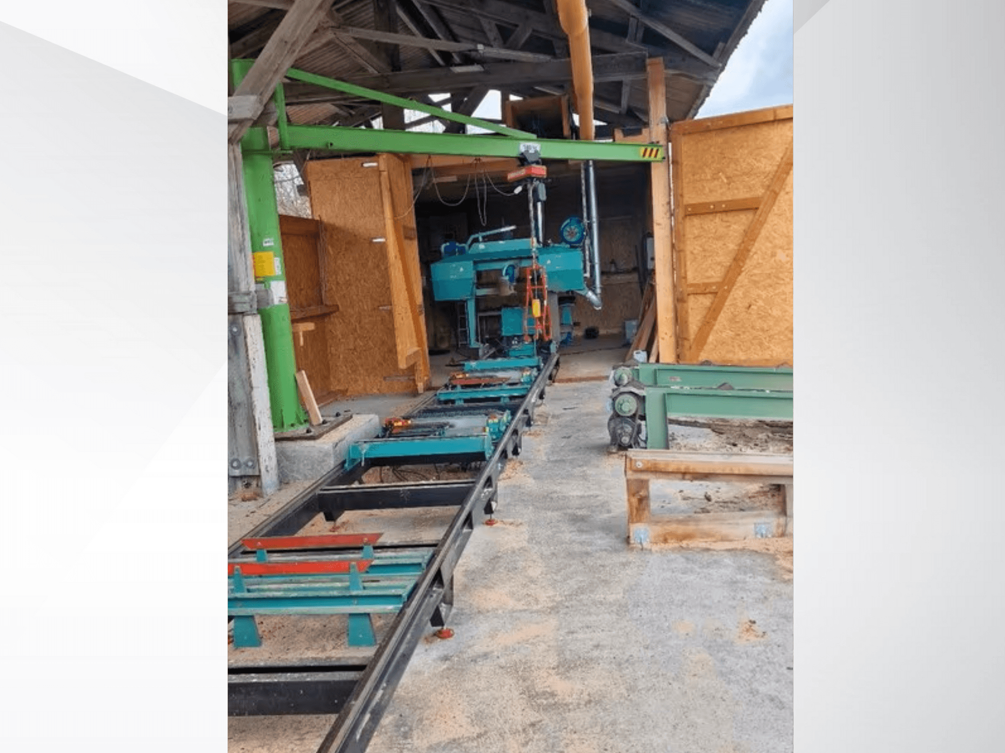 Horizontale Bandsägemaschine in der Werkstatt, von vorne gesehen. Zur Ausstattung gehören eine Schiene und weiteres grünes Zubehör.