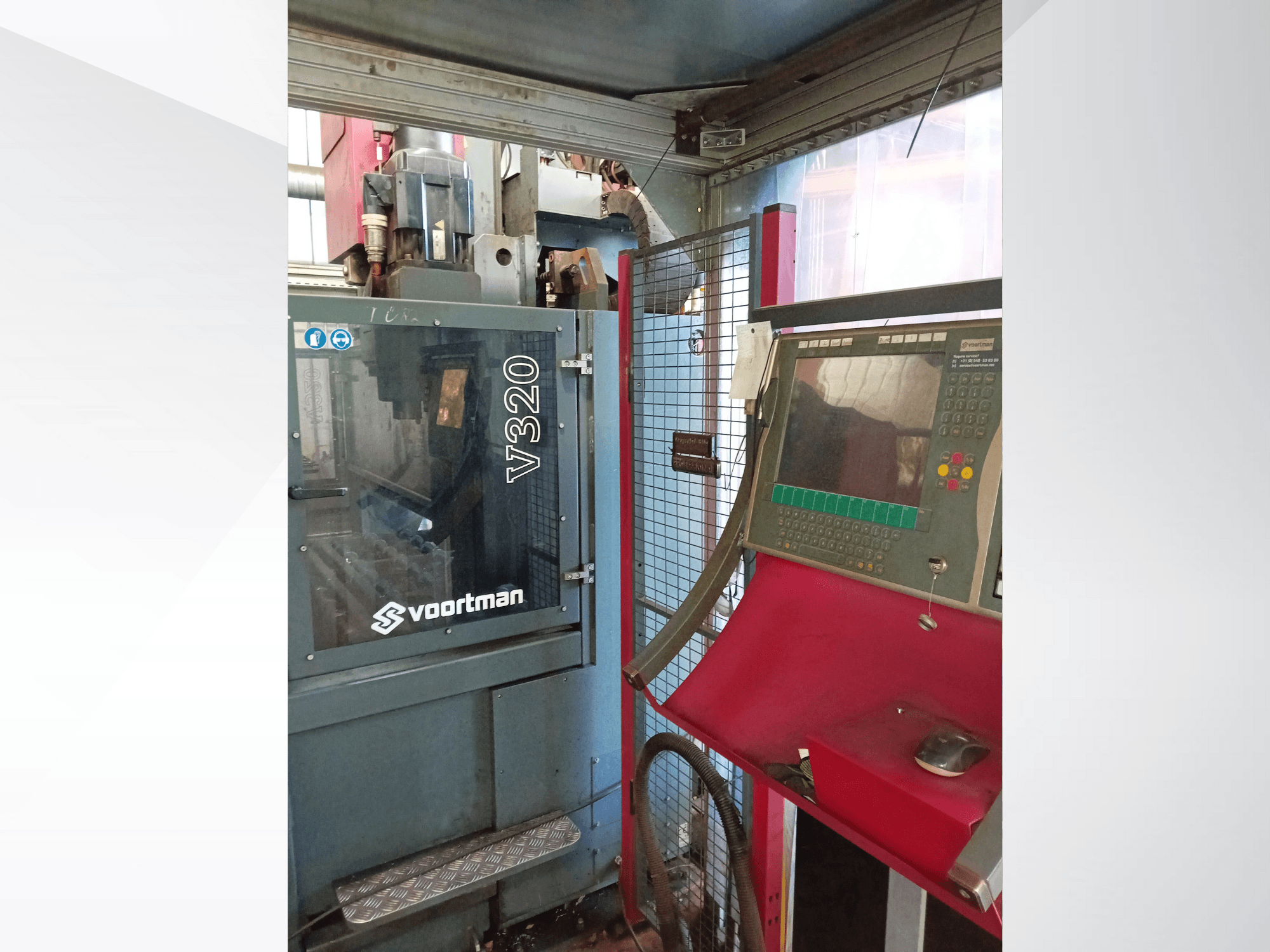 Vorderansicht der Voortman V320 CNC-Maschine, mit Bedienfeld mit Tasten, Bildschirm und Sicherheitsgitter.