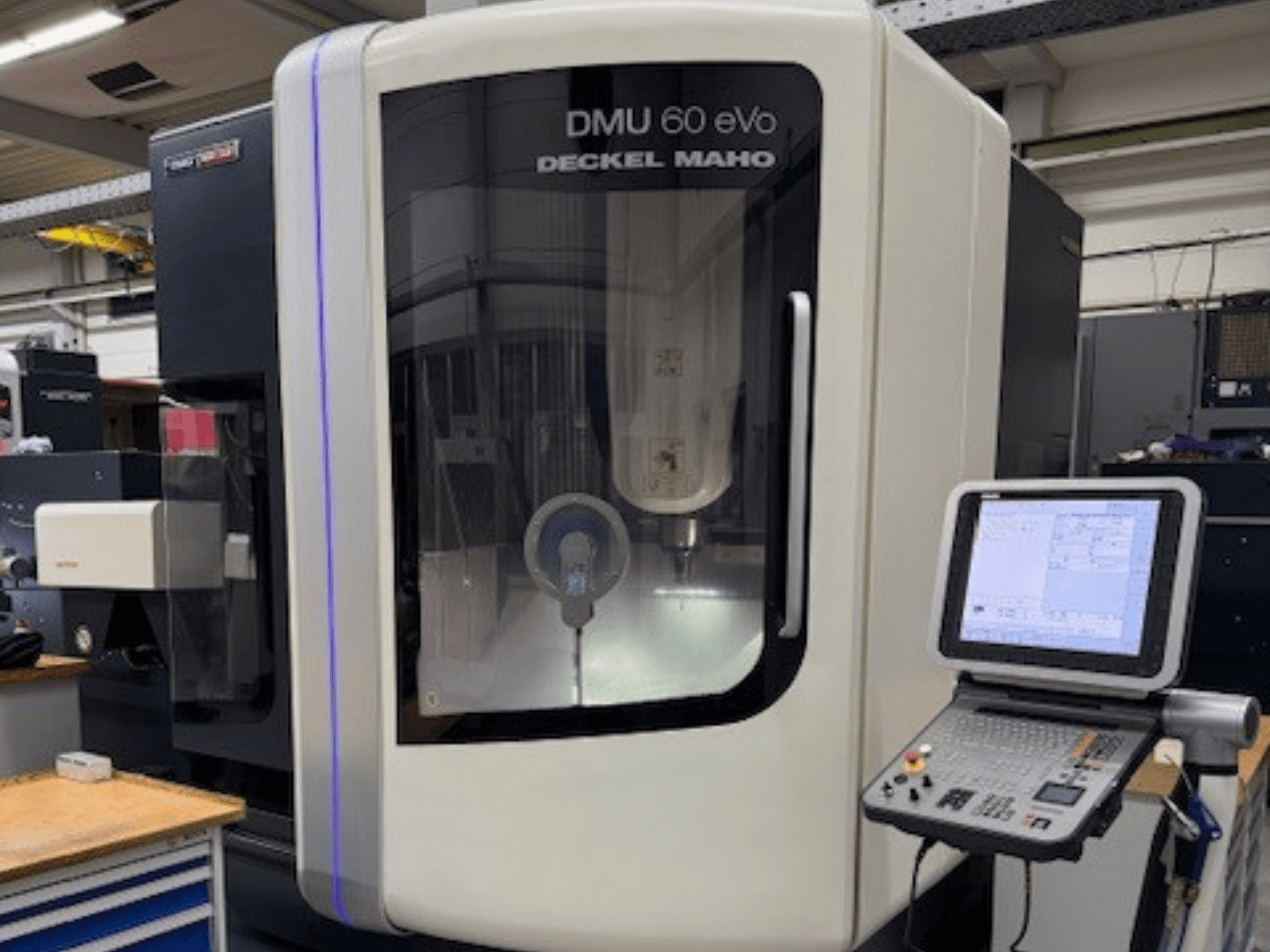 DMU 60 eVo by DECKEL MAHO, front view of CNC milling machine with control panel and display screen, showing precision components.