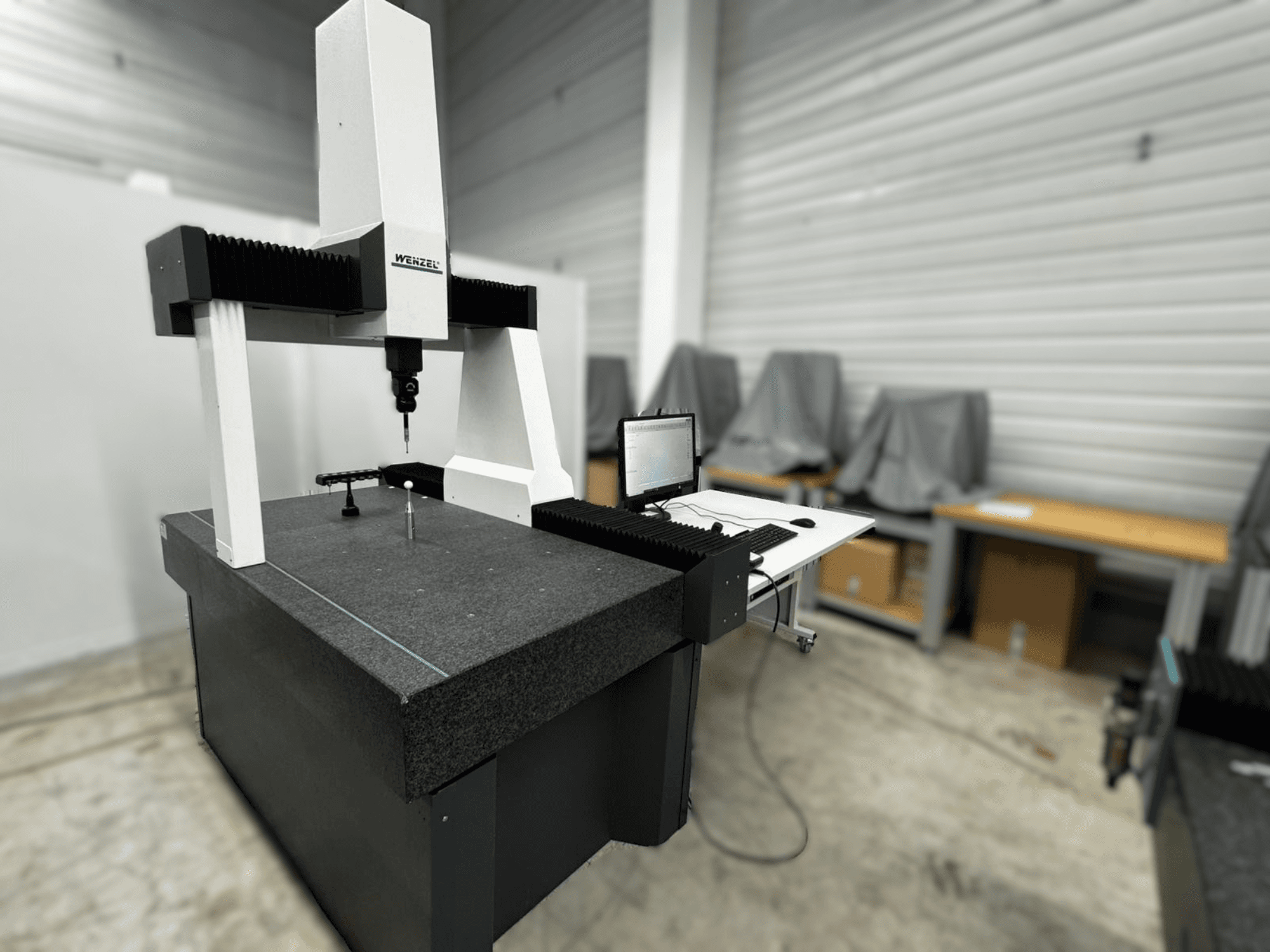 Wenzel-Koordinatenmessgerät LH 54 in der Seitenansicht mit Taster und Rechnerschnittstelle auf grauem Sockel.