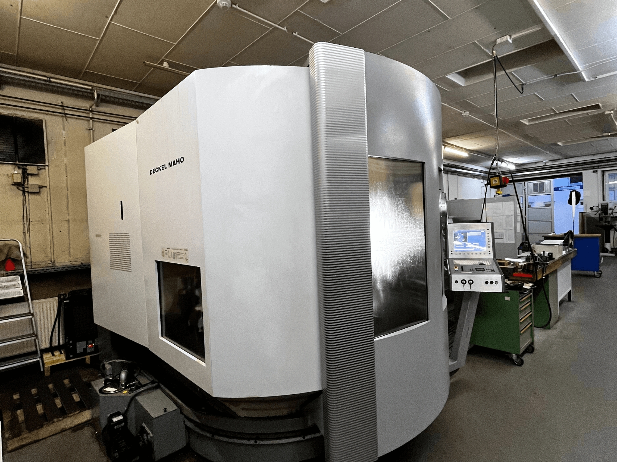 Deckel Maho CNC machine, front view, white exterior, control panel visible, workshop setting.