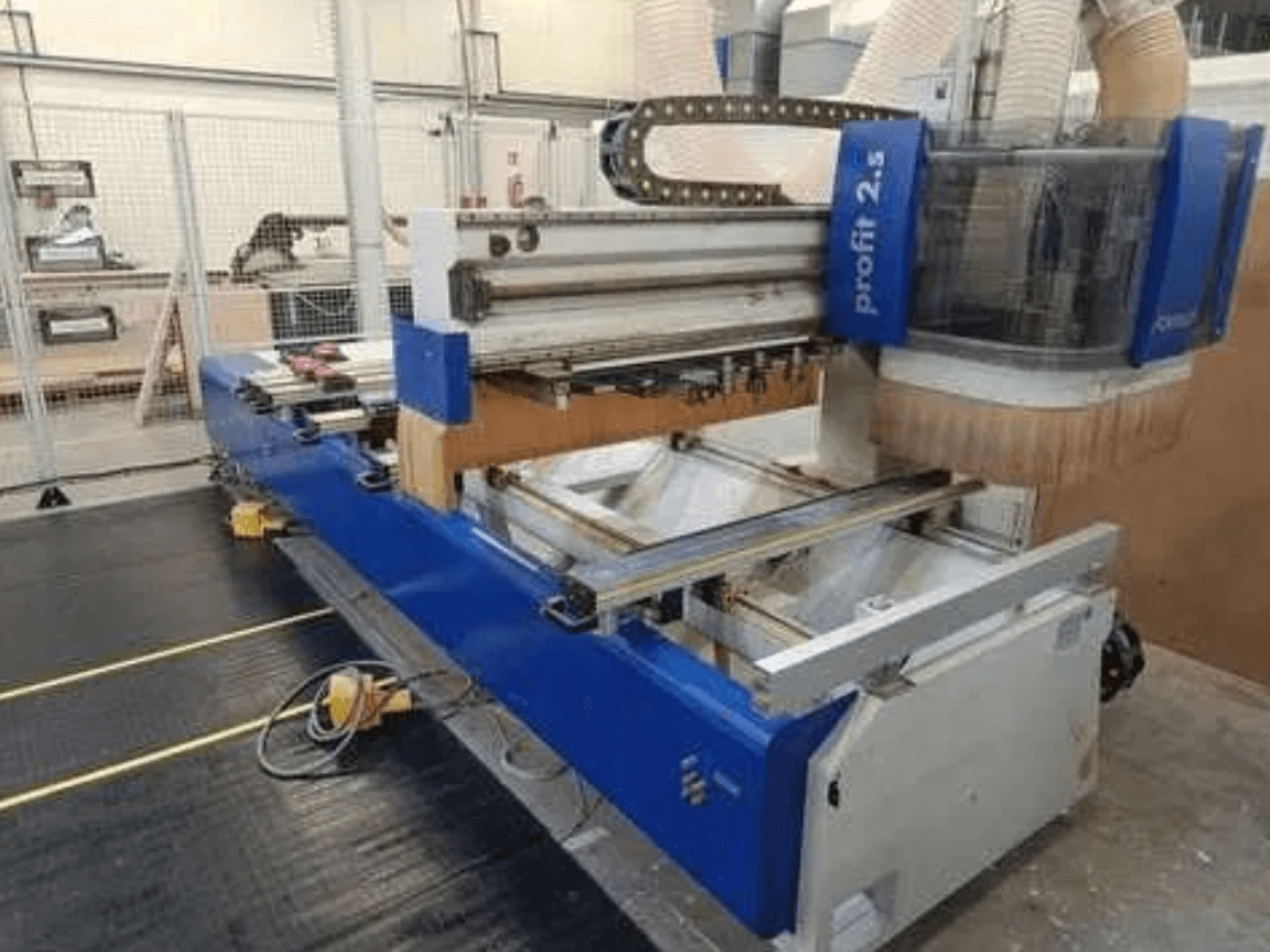 CNC-Maschine, Marke Profitec 2.5, Vorderansicht mit blauem Gehäuse, Arbeitsbereich und Staubabsaugung für die Holzbearbeitung.