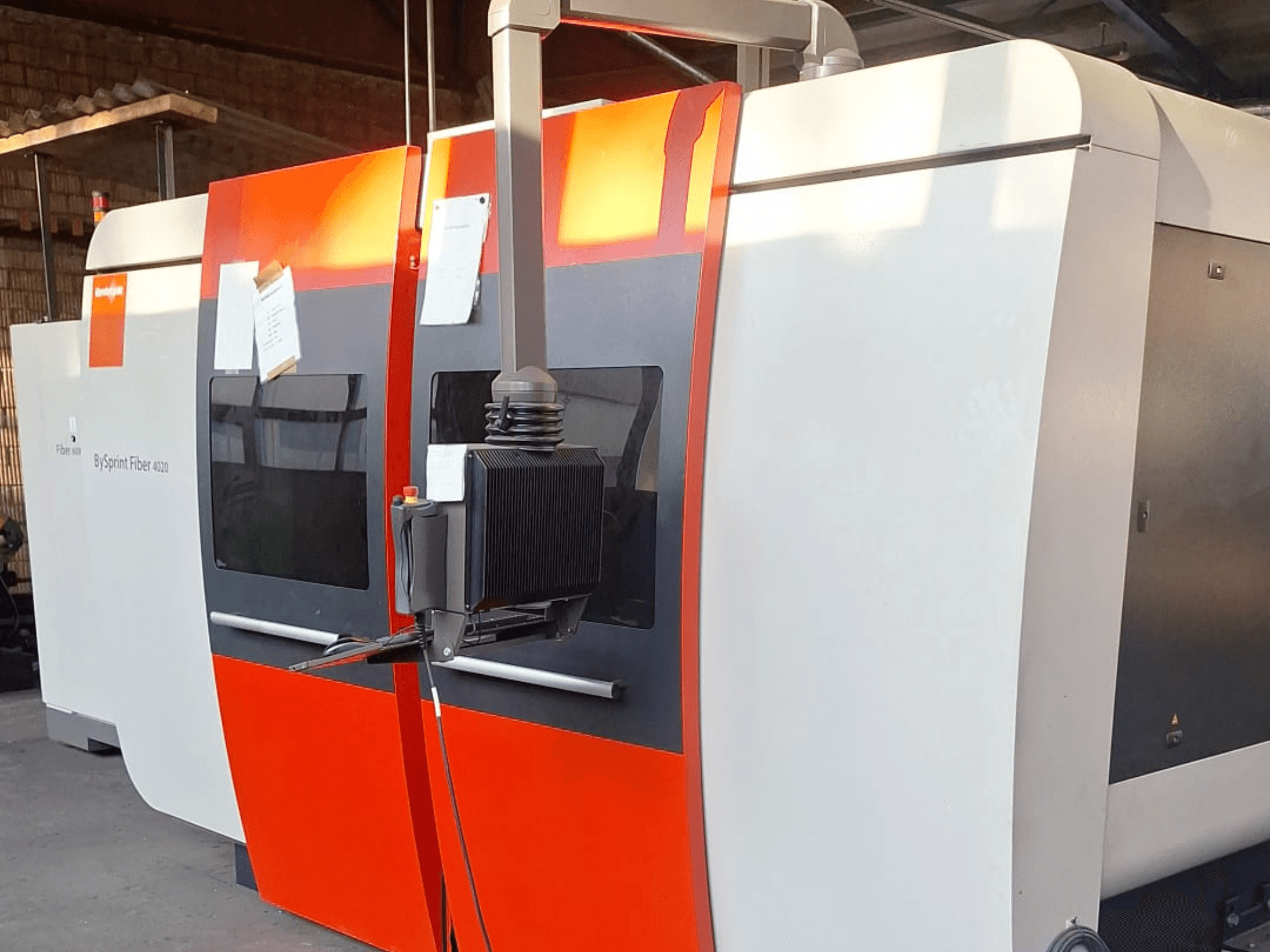 BySprint Fiber 4020 Laserschneidmaschine, Seitenansicht, mit rot-weißem Äußeren, detailliertes Bedienfeld sichtbar.