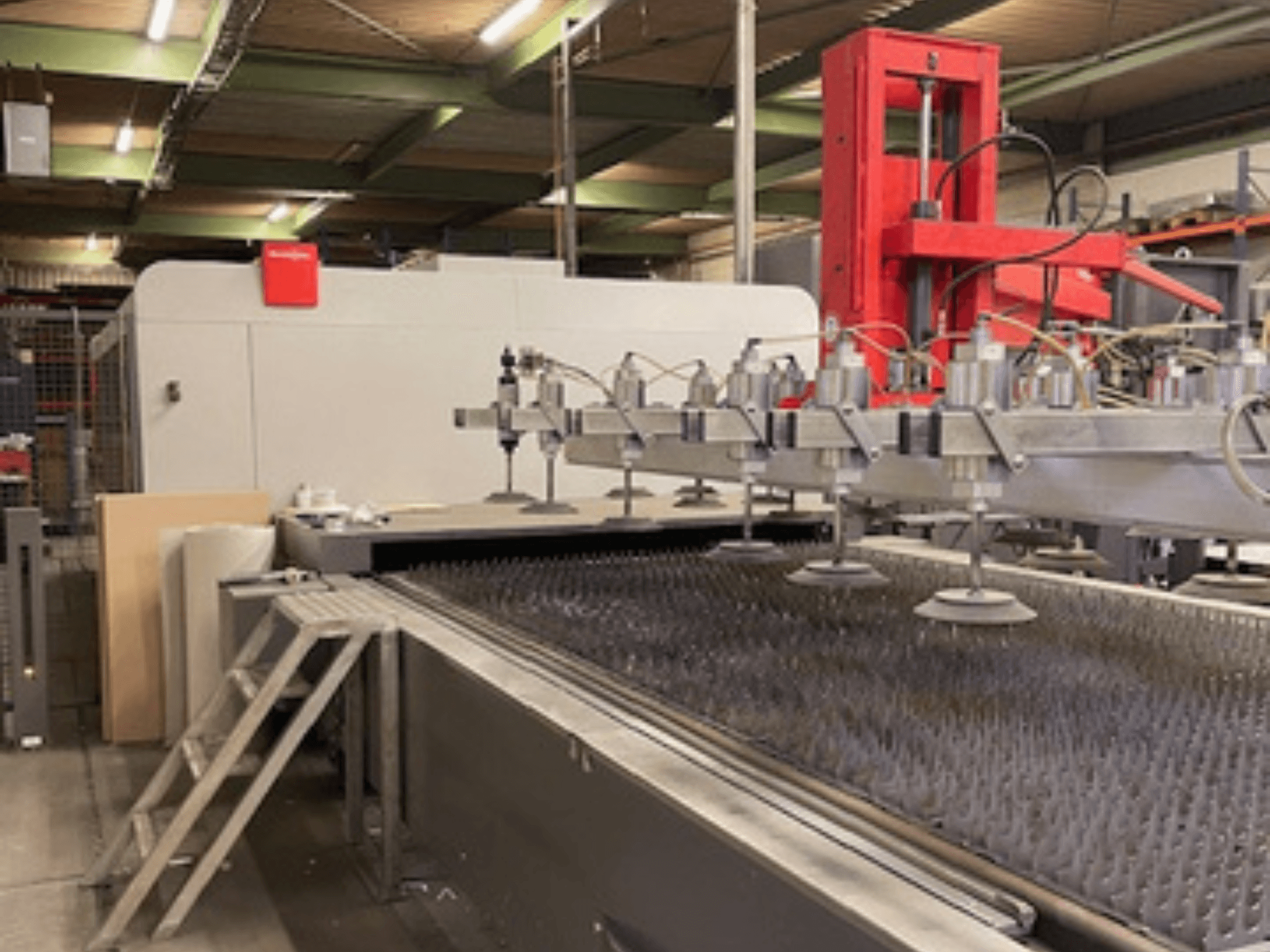 Bystronic BySprint Fiber 4020 Fiber 4Kw Frontansicht einer Faserlaserschneidanlage mit Düsen und Schneidbett.