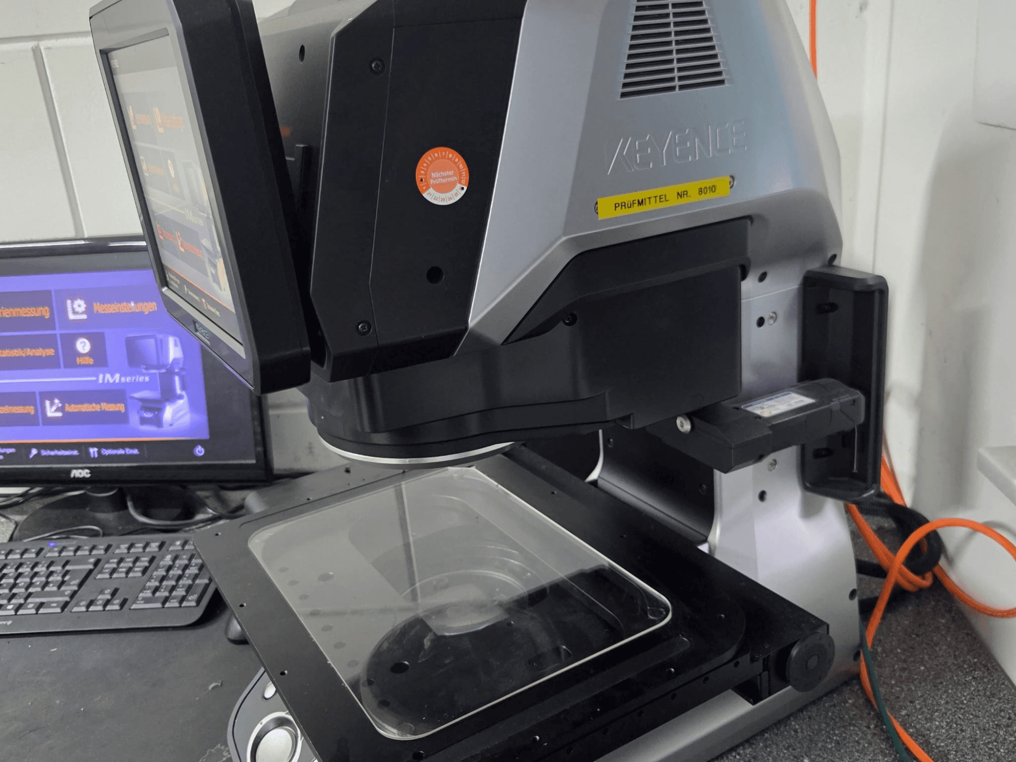 KEYENCE IM 7030 optisches Messgerät, Vorderansicht mit Touchscreen-Display und Glasmessplatte.