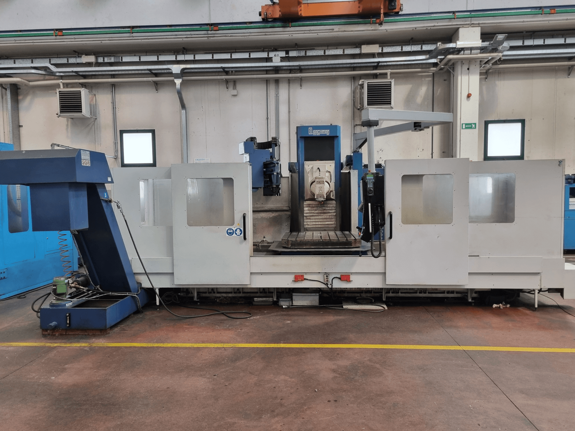 CNC-Fräsmaschine von "Brembana", Seitenansicht mit Bedienfeld und Arbeitsbereich mit einem Arbeitstisch im Inneren.