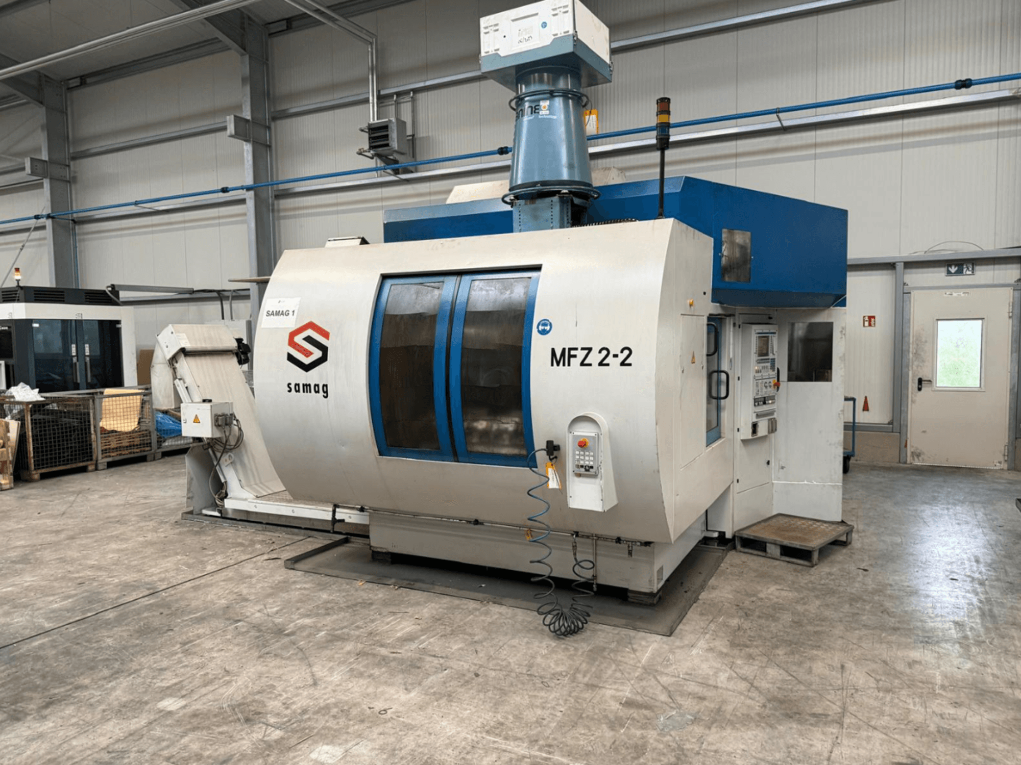 Samag MFZ 2-2 Werkzeugmaschine, Vorderansicht, mit Bedienfeld und blauem Deckel, mit Sicherheitseinrichtungen in einer industriellen Umgebung.