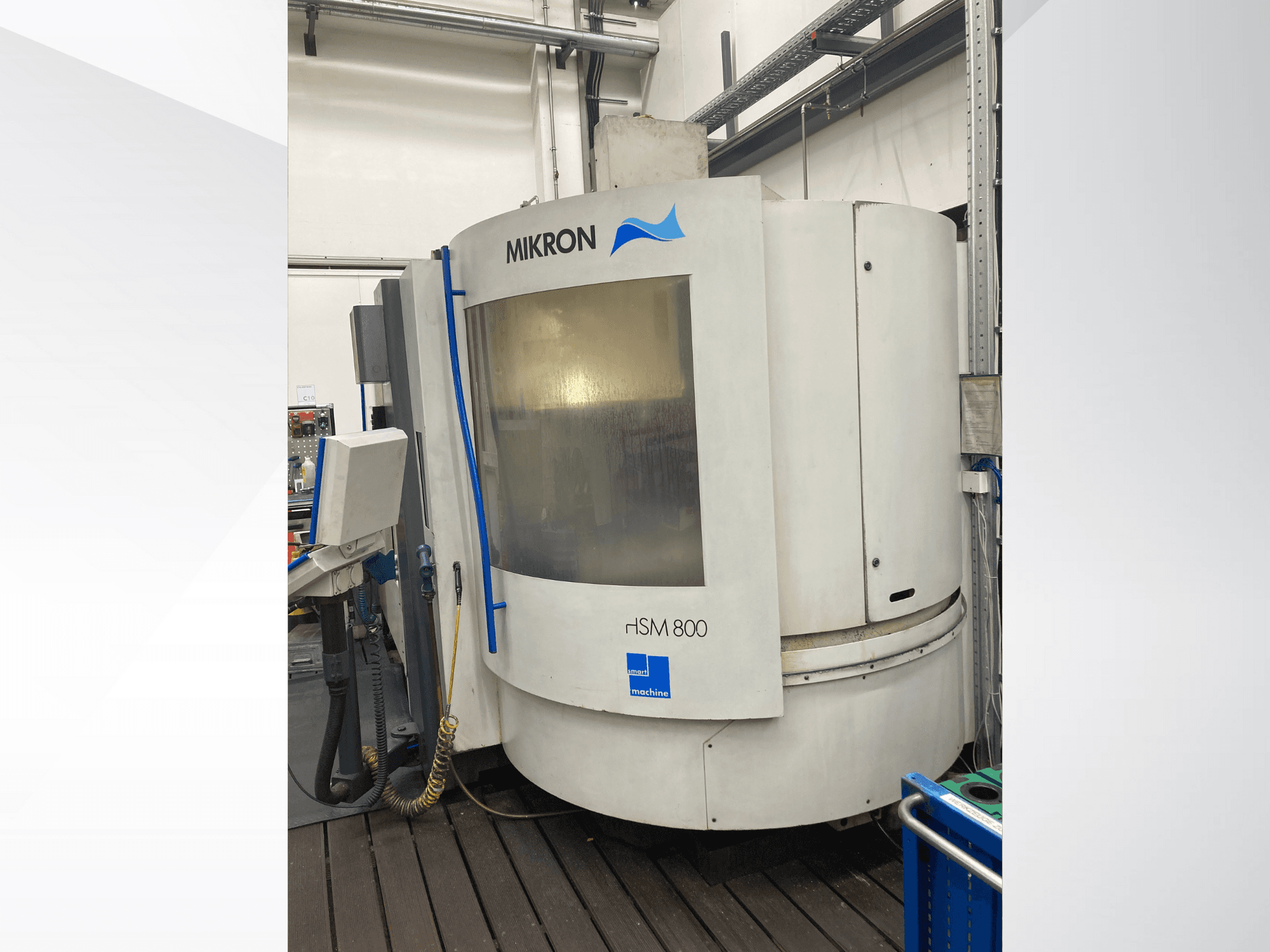 Mikron rISM 800 CNC-Maschine, Frontansicht mit Bedienfeld, zylindrischem Design und blauen Akzenten, in einer Werkstattumgebung.
