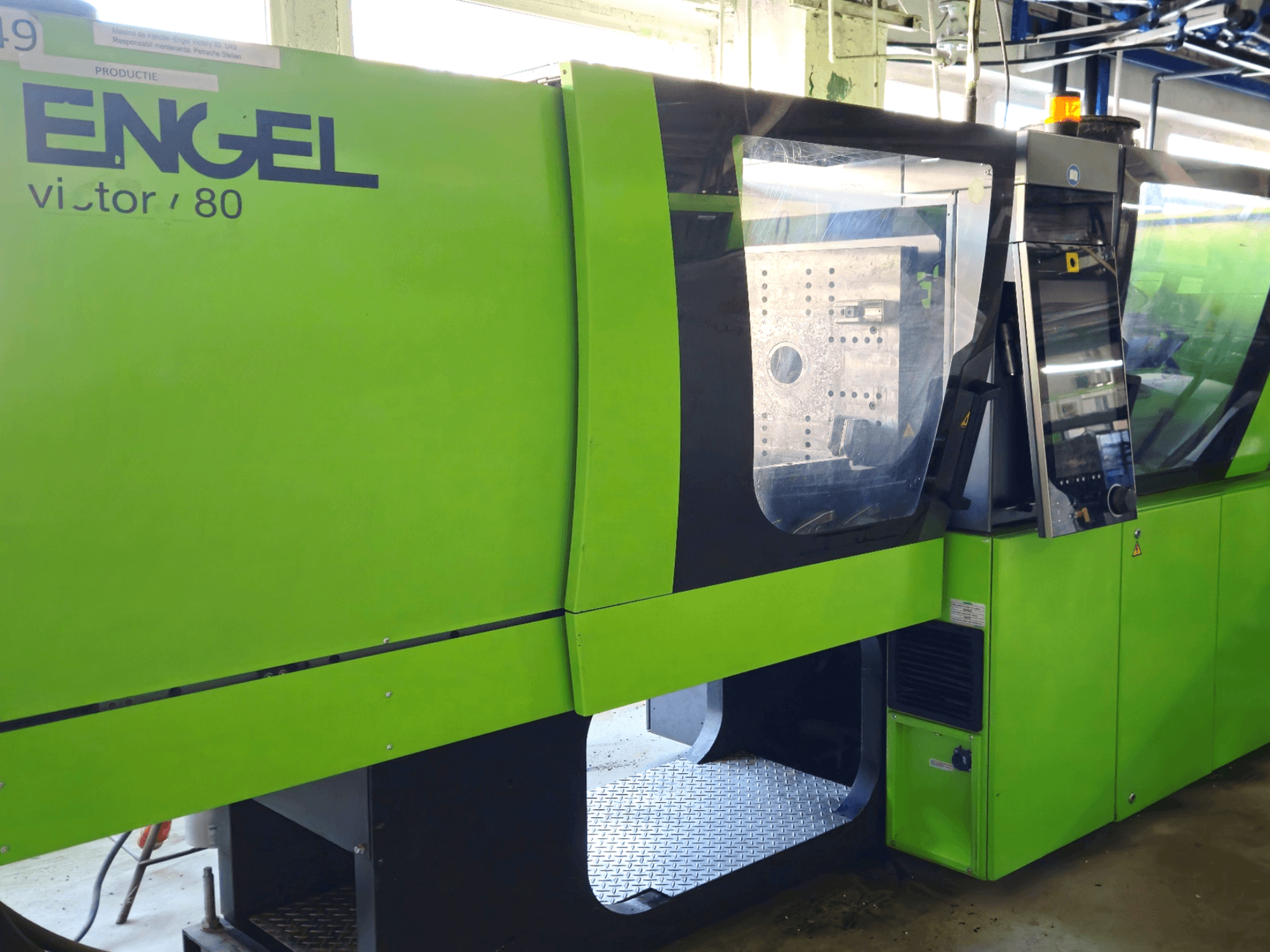 Engel victor 80 injection molding machine in green, front view, featuring control panel and transparent safety windows.