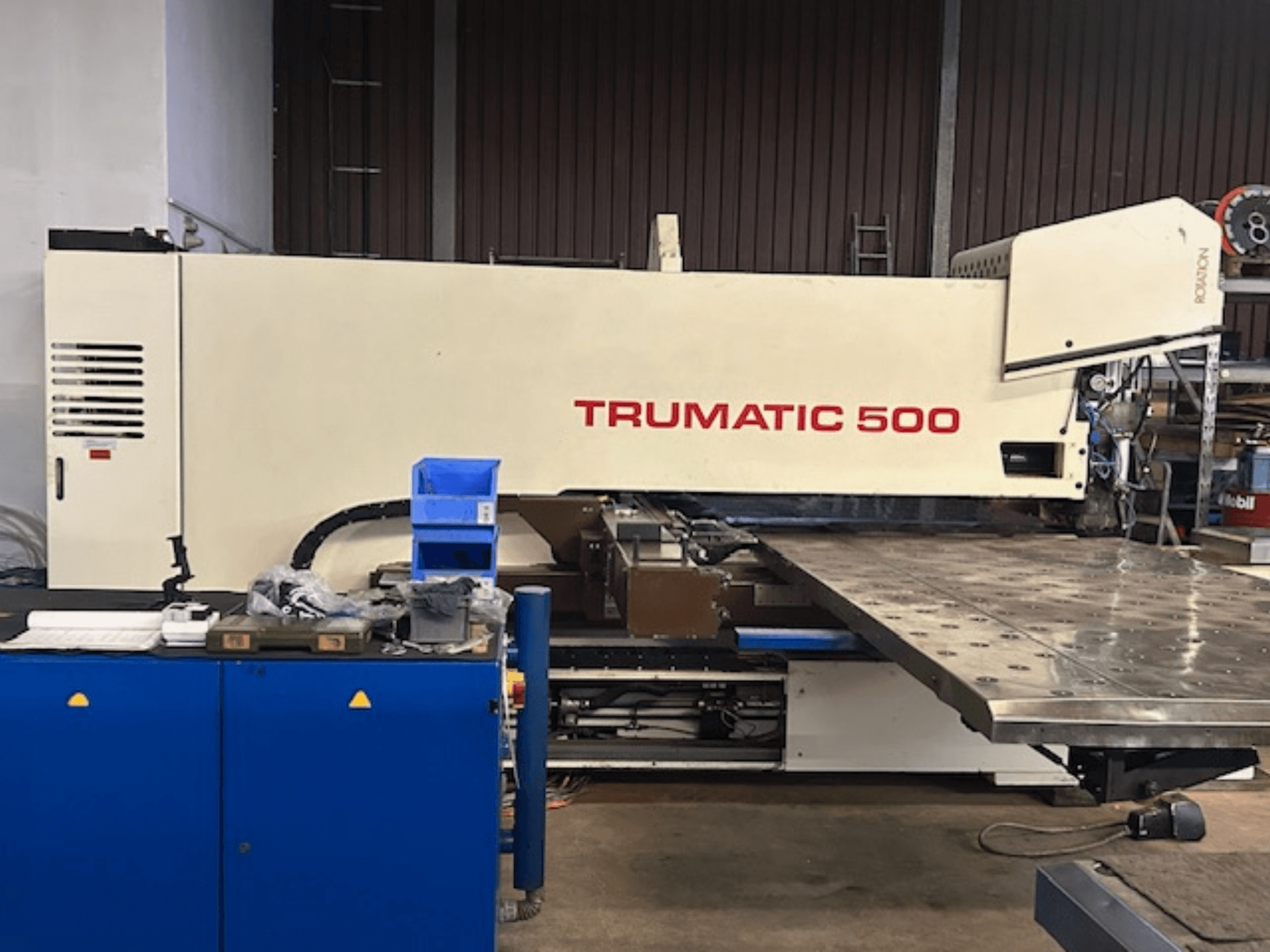 TRUMPF TRUMATIC 500 CNC-Stanzmaschine, Vorderansicht, mit Bedienpult und großem Arbeitstisch mit perforierter Oberfläche.