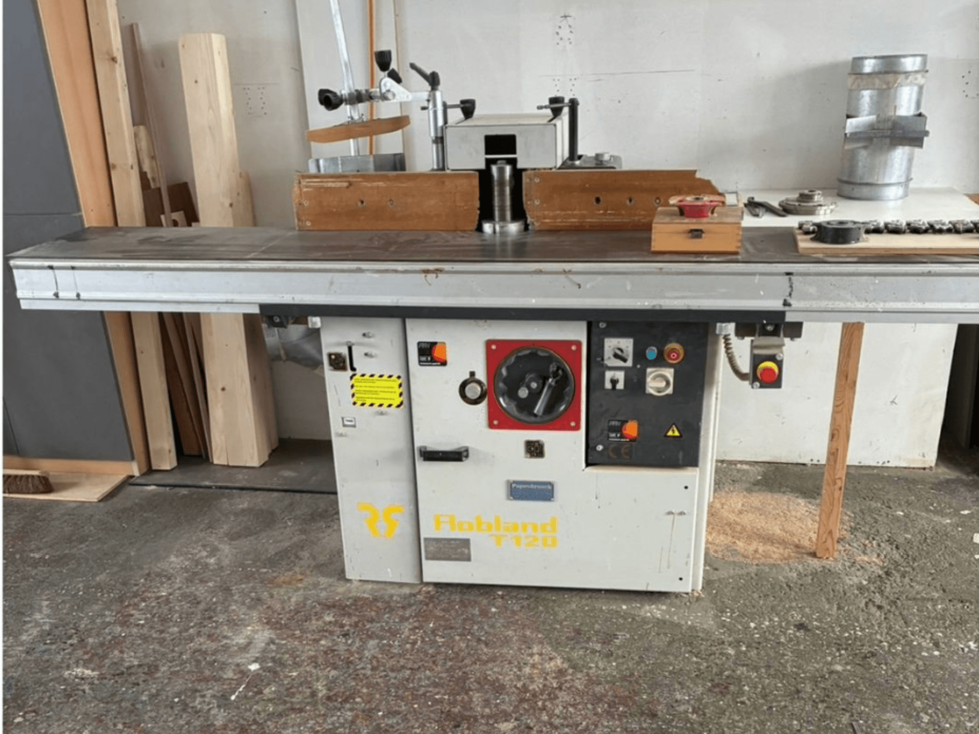 Hobbland T120 Tischhobelmaschine, Vorderansicht, mit silberner Oberfläche, Bedienfeld mit Tasten und Sicherheitsaufkleber.